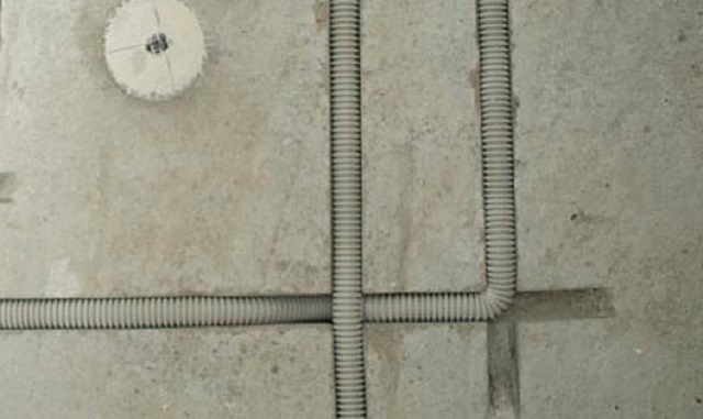 Штрабы, прорезанные в бетонной стене под гофрированные трубы электропроводки.